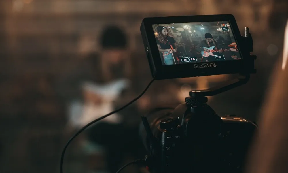 Caméraman qui film un homme faisant de la guitare